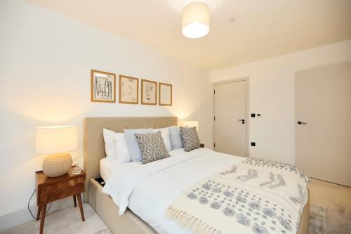 a bedroom with a large white bed and a table at The South Wimbledon Place - Adorable 2BDR Flat with Balcony in London