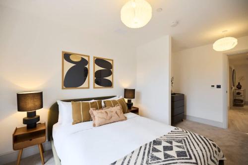 a bedroom with a white bed and two lamps at The South Wimbledon Place - Adorable 2BDR Flat with Balcony in London