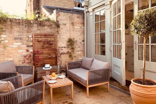 a patio with wicker chairs and a table at The Midsummer Common - Modern & Spacious 2BDR House with Garden in Cambridge