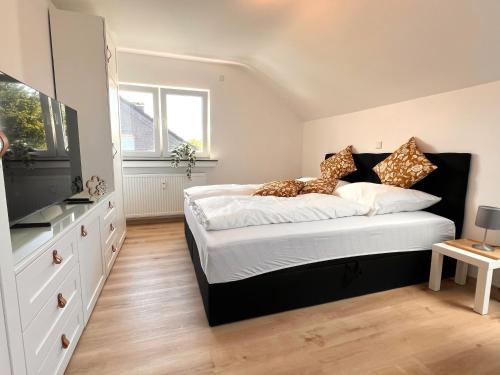 a bedroom with a large bed and a television at Modern und flexibel wohnen zwischen Köln und Düsseldorf in Langenfeld