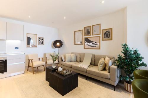 a living room with a couch and a table at The South Wimbledon Escape - Lovely 3BDR with Balcony in London