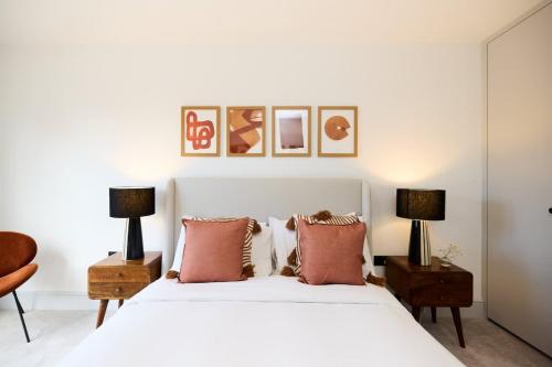 a bedroom with a white bed with two lamps at The South Wimbledon Escape - Lovely 3BDR with Balcony in London