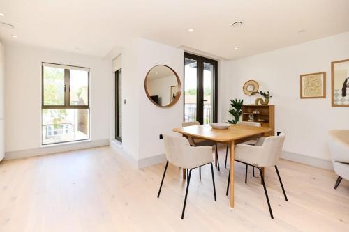 a dining room with a wooden table and chairs at The South Wimbledon Hideout - Fancy 1BDR Flat with Balcony in London