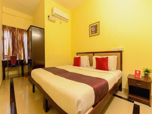 a bedroom with a large bed with red pillows at Super Hotel O Diamond In in Cochin