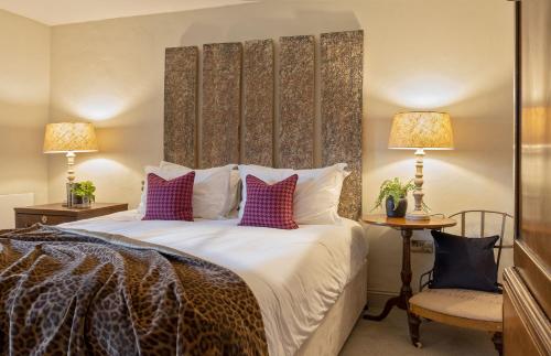 a bedroom with a large bed with purple pillows at Jack's Barn and Deerleap in Bath