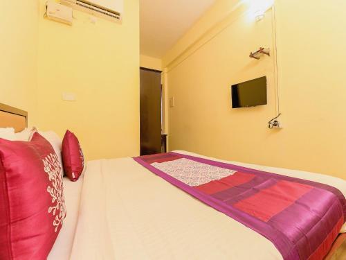 a bedroom with a bed and a tv on the wall at Super Hotel O Diamond In in Cochin