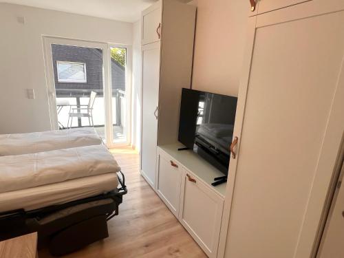 a bedroom with a bed and a flat screen tv at Modern und flexibel wohnen zwischen Köln und Düsseldorf in Langenfeld
