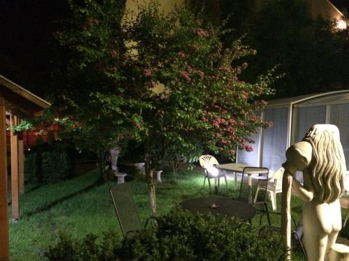 a backyard with a table and chairs and a tree at BL Luxus Apartman in Szeged