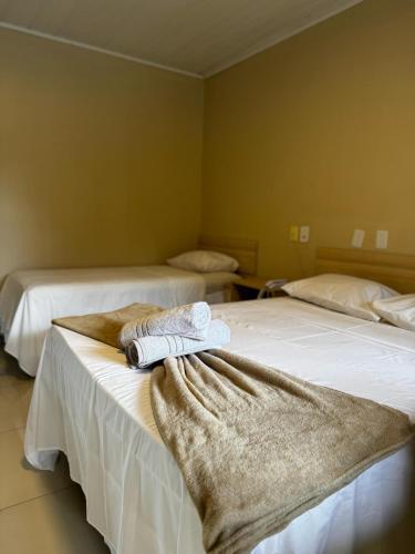 two beds in a room with towels on them at Pousada Itajuípe- Unidade Itabuna-Ba in Itabuna