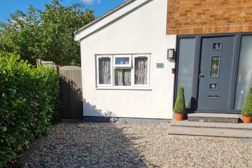 a house with a blue door and a gravel driveway at 1 Bed-Sleeps 2-Parking-Garden-2 min train station in Harlow