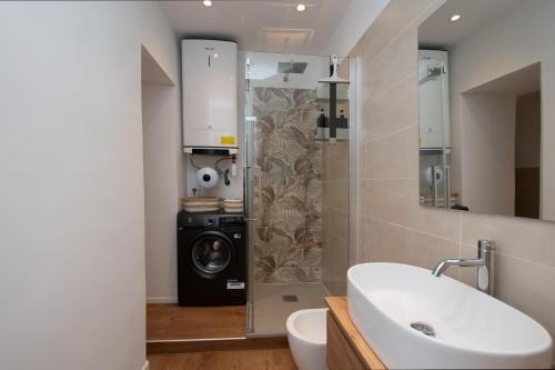 a bathroom with a sink and a washing machine at La casa del Viaggiatore in Savona