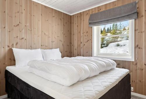 un grande letto bianco in una stanza con una finestra di Cozy cottage in Bjørgan 