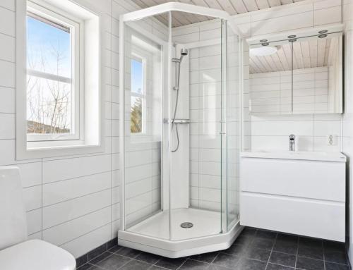 un bagno bianco con doccia e lavandino di Cozy cottage in Bjørgan 