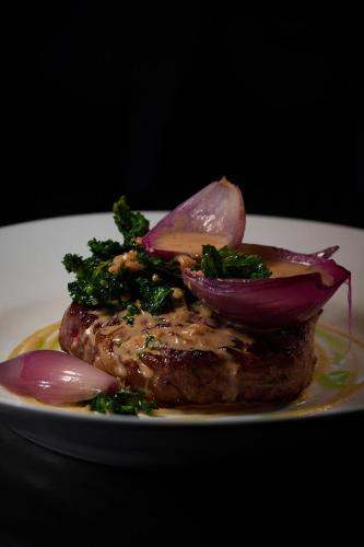 a piece of meat with onions and broccoli on a plate at Tannery Townhouse in Dungarvan