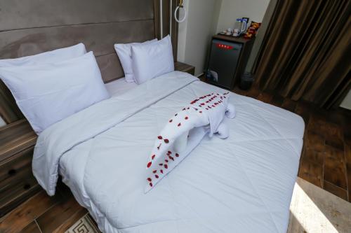 a white bed with a stuffed animal on it at Rotana Pyramids View in Cairo