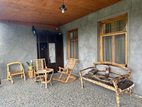 a porch with chairs and a bed and a table at Nadirashvili Guest house 