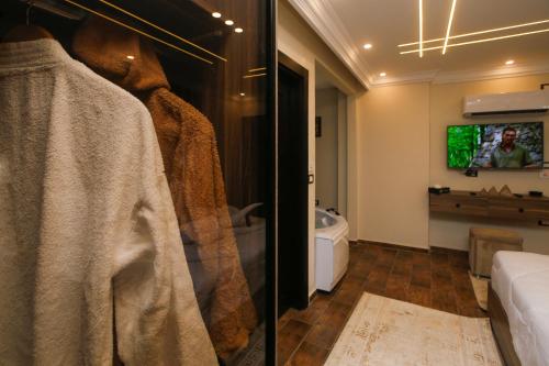 a room with a tv on a wall and a bedroom at Rotana Pyramids View in Cairo