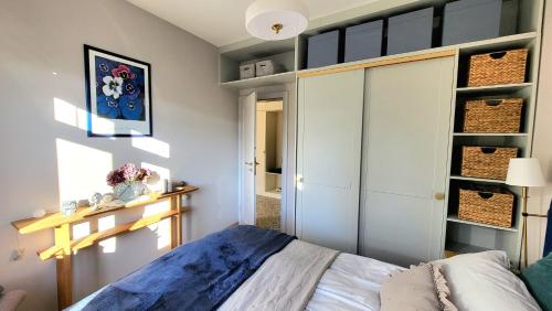 a bedroom with a bed and a closet with baskets at Apartamenty EverySky Kowary, Cozy Home z widokiem na góry i windą in Kowary