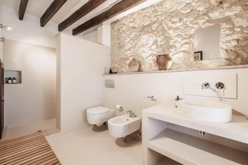 a white bathroom with a sink and a toilet at The Old Cottage - Cas Julians Sencelles Ruberts in Sencelles