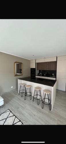 une cuisine avec trois tabourets de bar et un comptoir dans l'établissement Cala di mare, à Saint-Florent