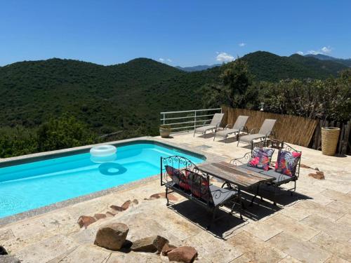una piscina con sillas y un banco junto a ella en Villa CAROLE Piscine privée Spa Fautéa, en Zonza