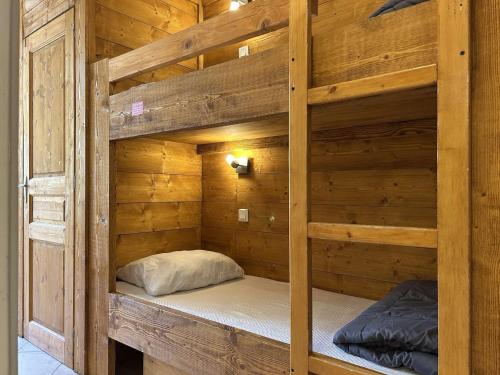 Ce lit superposé se trouve dans un dortoir doté de murs en bois. dans l'établissement Studio modernisé PMR, balcon sud 4 pers - Montgenèvre - FR-1-330D-33, à Montgenèvre