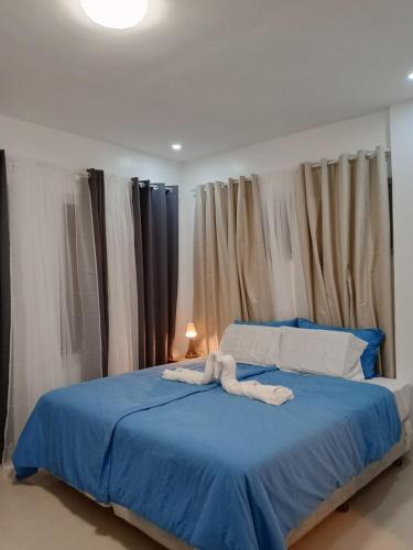 a bedroom with a blue bed with towels on it at Oia in Moalboal