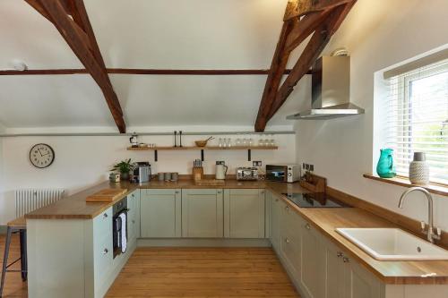a kitchen with white cabinets and a counter top at Spacious 2 Bedroom Coach House in Cley Norfolk in Cley next the Sea