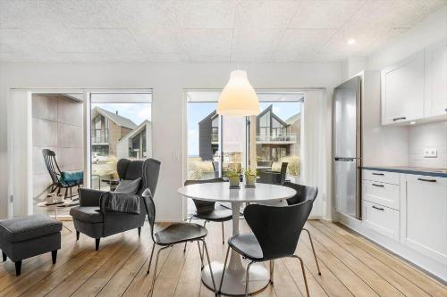 a kitchen and dining room with a table and chairs at 9930-Hvide-Sande-Langsand-106-stuen in Hvide Sande