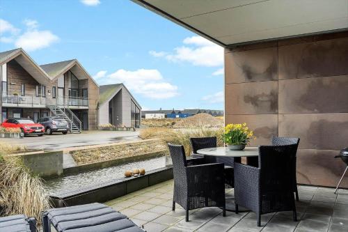 a patio with a table and chairs and a building at 9930-Hvide-Sande-Langsand-106-stuen in Hvide Sande