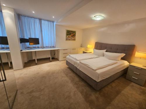 a bedroom with a bed and a desk in it at Hotel Adler - Weil am Rhein in Weil am Rhein
