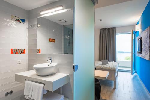 a bathroom with a sink and a mirror at Pharos Hvar Hotel in Hvar