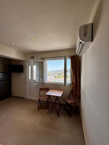 a room with a table and chairs and a window at Kotronia Suites in Skiathos Town
