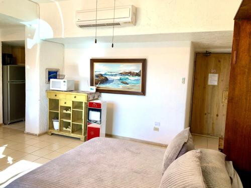 a bedroom with a bed and a painting on the wall at Marina Cabo Plaza in Cabo San Lucas