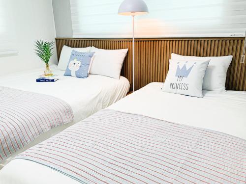 two beds sitting next to each other in a room at Cozy Erin Stay, Seoul in Seoul