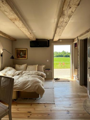 a bedroom with a bed and a large window at Snickarboden in Ingelstad
