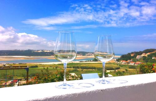 three wine glasses sitting on top of a ledge at Casa Encosta da Lagoa in Foz do Arelho