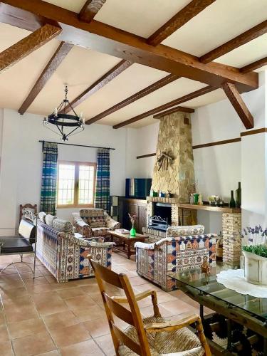 a living room with a table and a stone fireplace at Casa rural El Arado in Baena