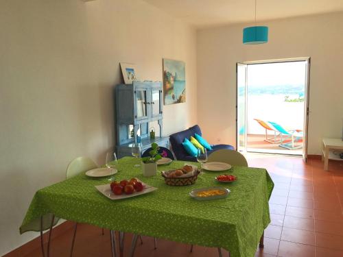 a table with a green table cloth with fruit on it at Casa Encosta da Lagoa in Foz do Arelho