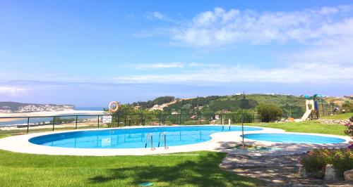 a large swimming pool with a view of the ocean at Casa Encosta da Lagoa in Foz do Arelho