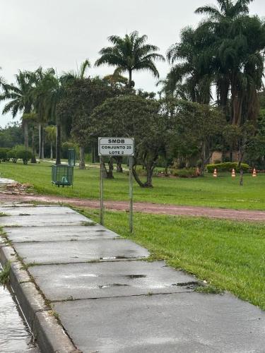 a street sign next to a park with palm trees at Flat da Cassia Eller na Villela Home Stay Lago Sul DF in Brasilia