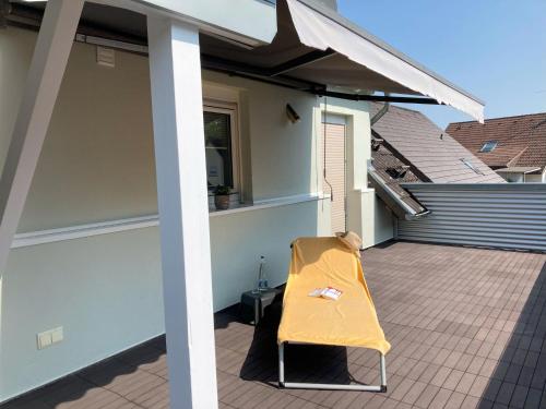 a yellow chair sitting on the patio of a house at Ferienwohnung Hoffmann in Homburg