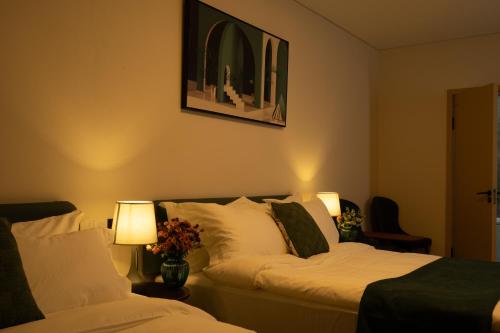 a hotel room with two beds and two lamps at MSInternational Hotel in Ulaanbaatar