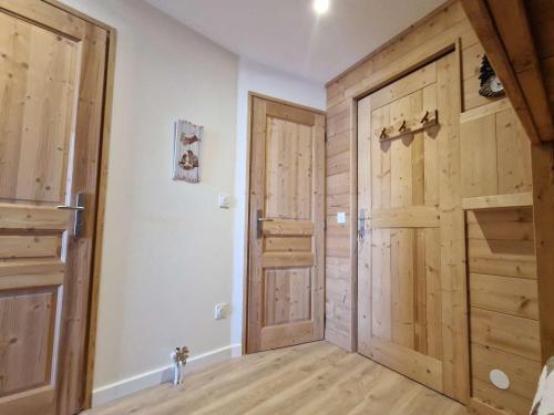 - un couloir avec des portes en bois dans une maison dans l'établissement Studio cosy pour 4 pers à L'Alpe d'Huez, près des pistes, animaux bienvenus - FR-1-405-14, à L'Alpe-d'Huez