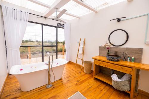 a bathroom with a tub and a window at Nanare Chalets Amboseli in Poka