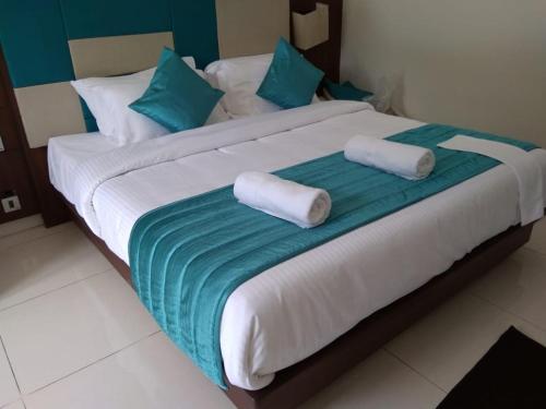 a large bed with two rolled towels on it at De Orchid Resort in Agonda