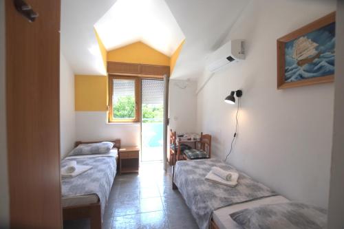 a room with two beds and a window at Apartmani HRGA in Vodice
