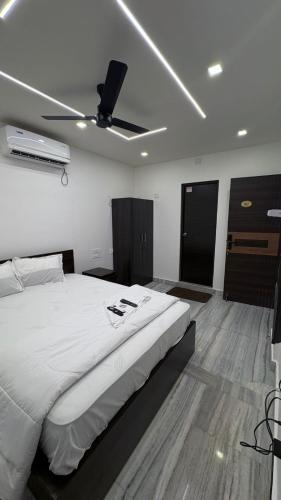 a bedroom with a large bed with a ceiling fan at VV Guest Inn in Nellore