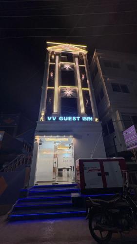 a building with a sign that says we must live at VV Guest Inn in Nellore