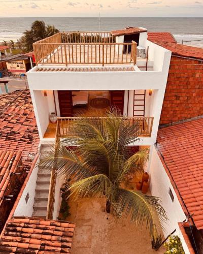 an aerial view of a house with a palm tree at Casa Tartaruga Emboaca Trairí in Trairi